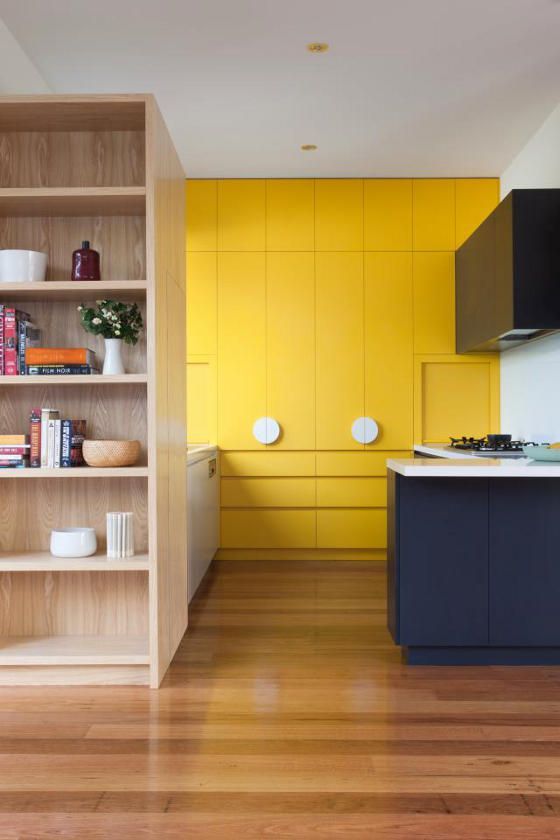 parete contenitore gialla, in cucina neutra (nero, bianco e legno chiaro)