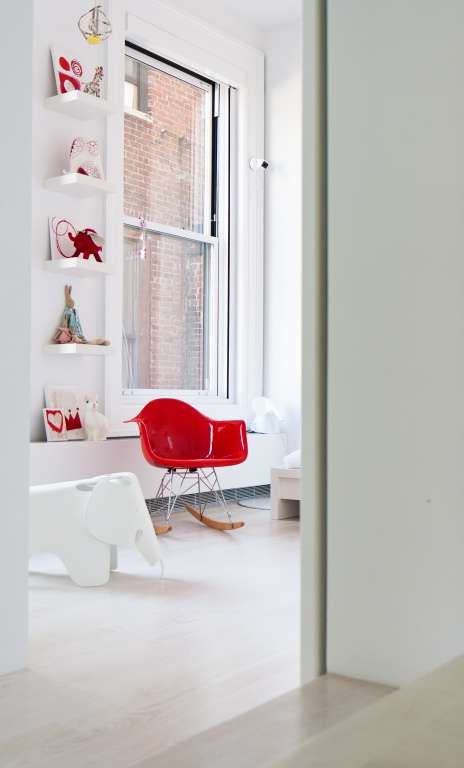 Interno neutro con poltroncina Eames Plastic Chair rossa.