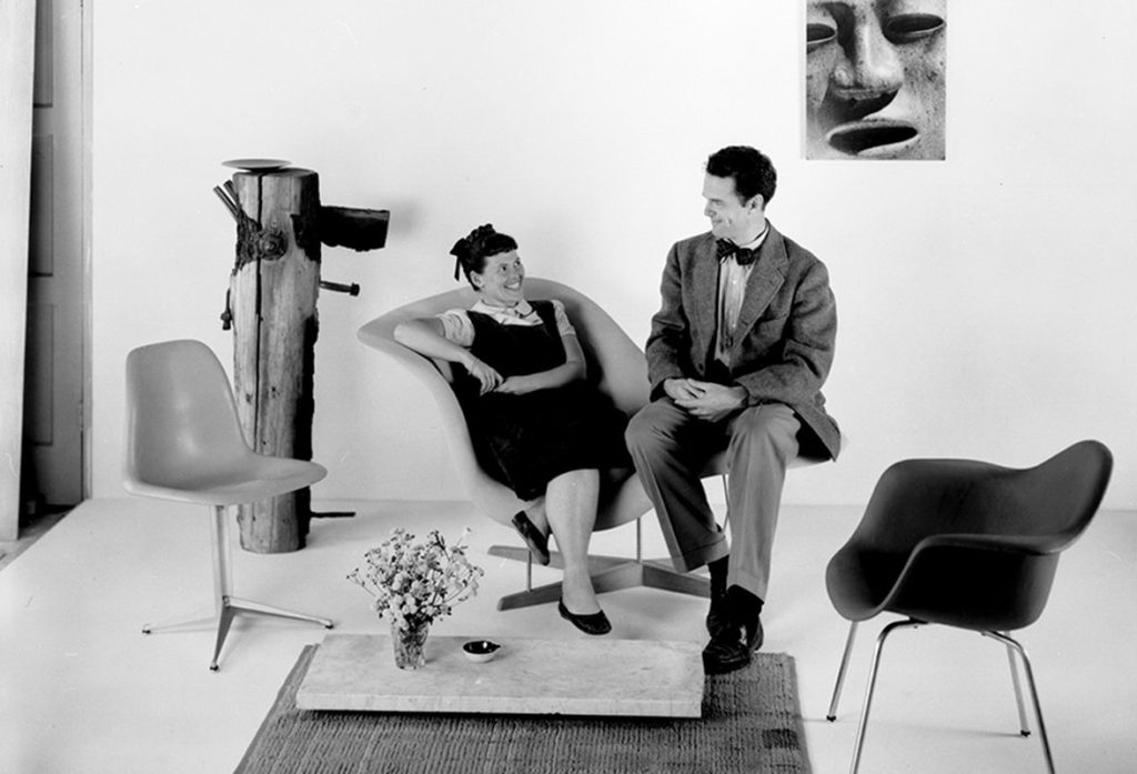 Ray e Charles Eames nel salotto, seduti sulla chaise longue che hanno progettato 